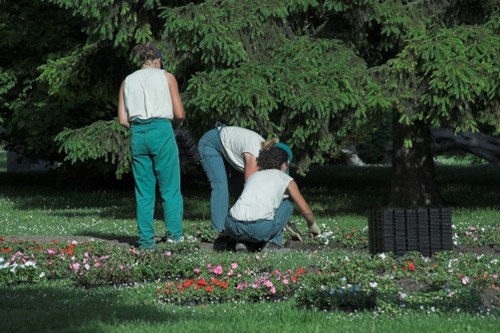 Operative wearing PPE while operating a strimmer in a garden